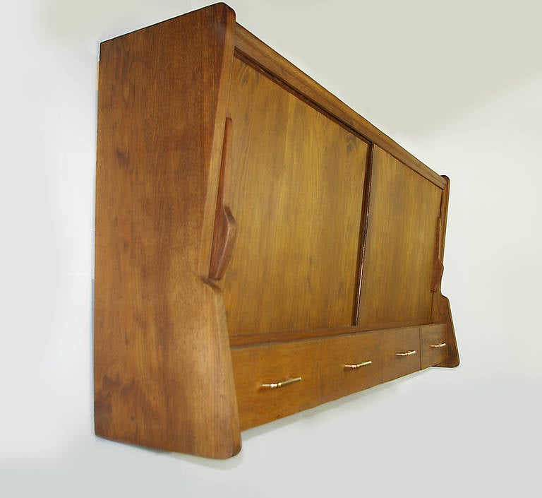 Remarkable oak wall-mounted cupboard. Four drawers with brass handles four adjustable oak shelves. Other furniture from the same series are available.