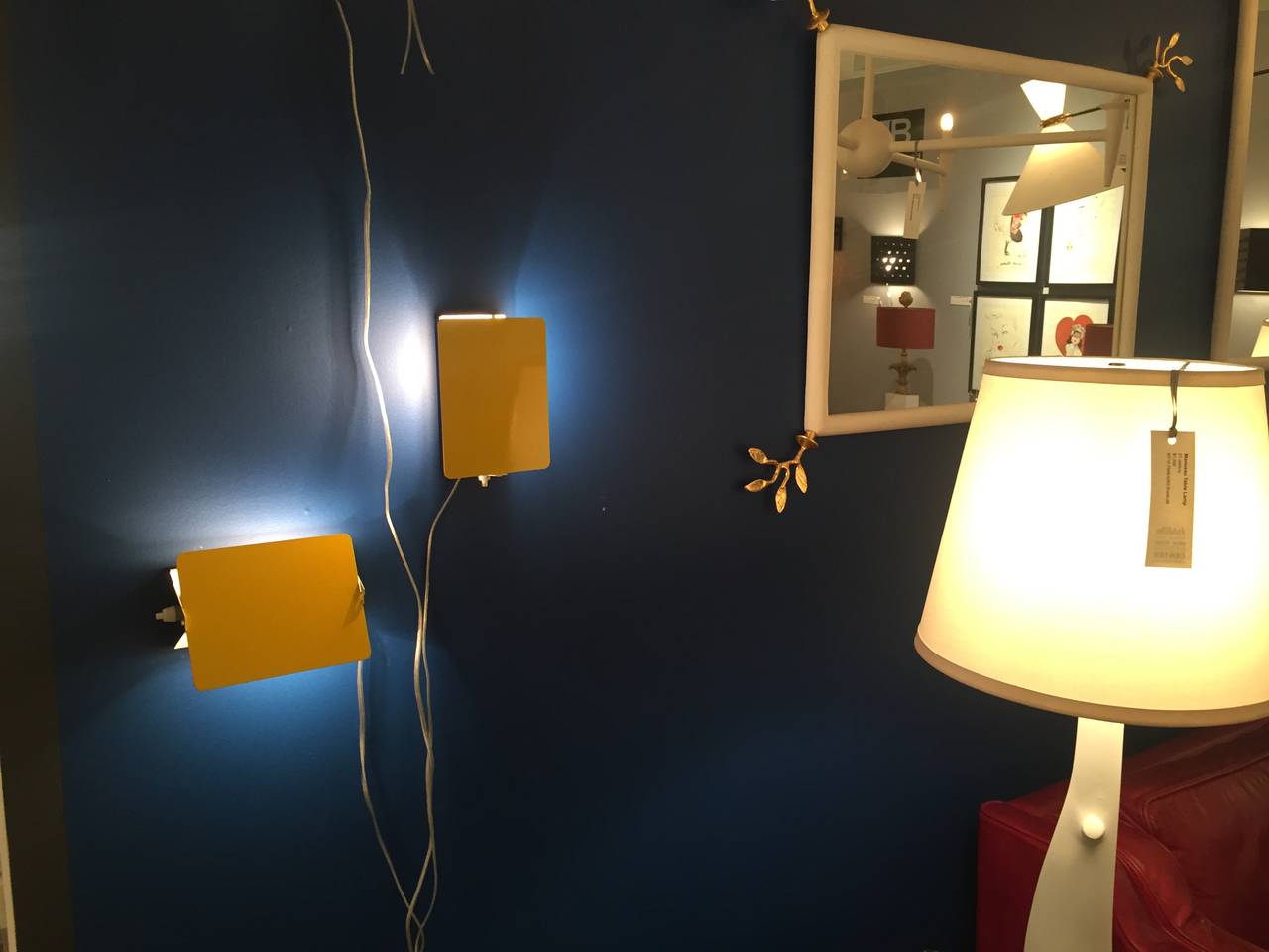 Two yellow wall sconces designed by Charlotte Perriand in the 1950s.  The lights have the pivoting flap which create a nice subtle light which you can direct where you want.  Can be placed either vertically or horizontally.  The lights have a single