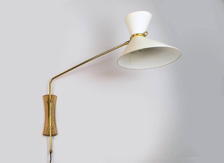 Elegant mid-century sconce with a diabolo shade.
The brass stem attached to the wooden back plate slides 10