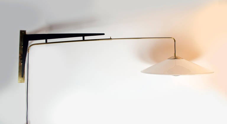The details of this wall sconce make a beautiful arty light fixture. The light pivots on the brass back plate and will adjust in its height and projection. The counterweight and the bulb element provide an additional touch of sophistication. Light