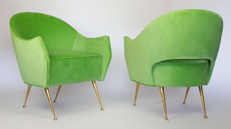 Two elegant chairs with cast brass legs and a distinctive curved back.  These chairs are very comfortable, perfect in size and have been upholstered in a lime green velvet.   The beauty of the tapered brass legs with their graceful feet are sure to