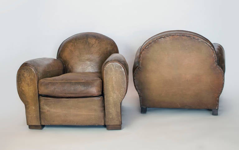Two leather club chairs with their original leather. Frame has been reinforced, they are in great shape for their age. Great patina. It has its original seat cushion which has been restuffed with a new down insert.