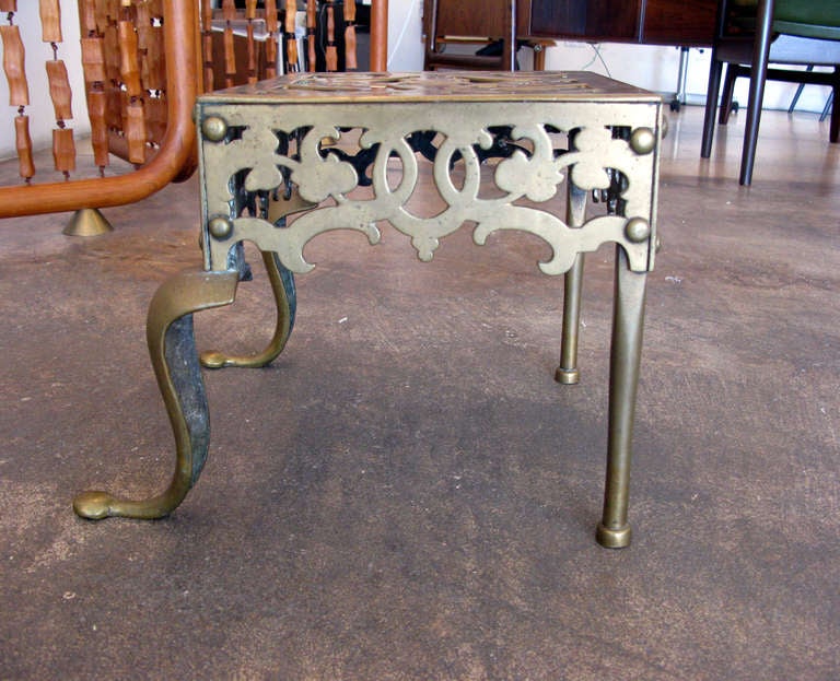 Very old, solid brass footman stool.  These were typically used for large pots, kettles, etc. in a working kitchen fireplace.  Great patina from age.  Likely from the mid 1800's.