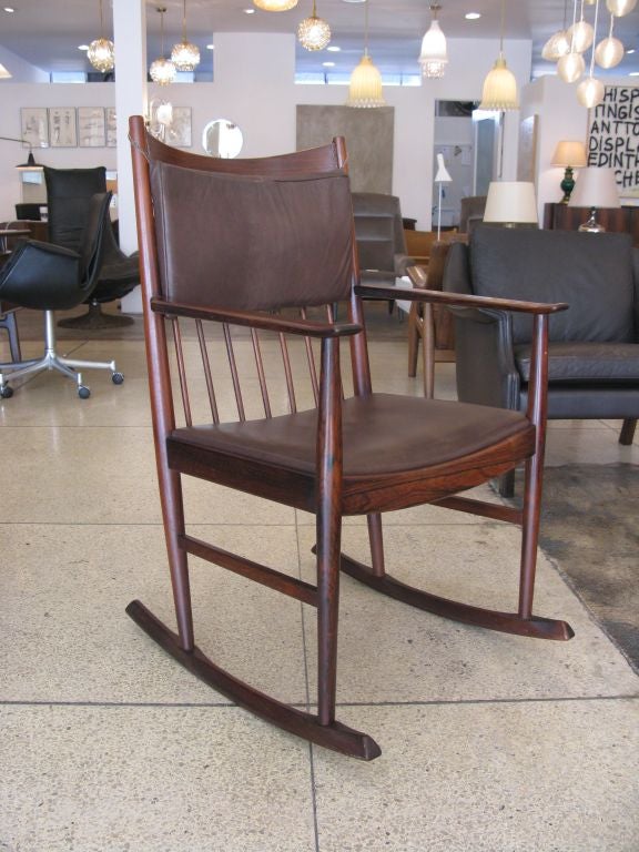 Rocking chair designed by Arne Vodder for Sibast.  Rosewood frame with brown leather upholstered seat and loose back cushion.  Seat measures 17.5