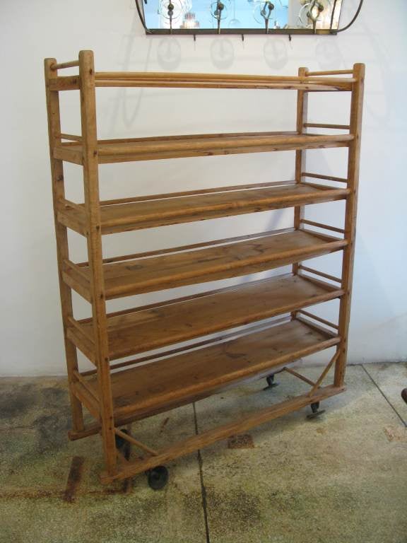 Wooden rolling baker's cooling rack from the early 20th century.  Wooden frame with unique aged metal wheels.  Perfect for storage or for use as a wine rack.

* ON SALE until Friday, 2/1/13.  No additional discounts apply.