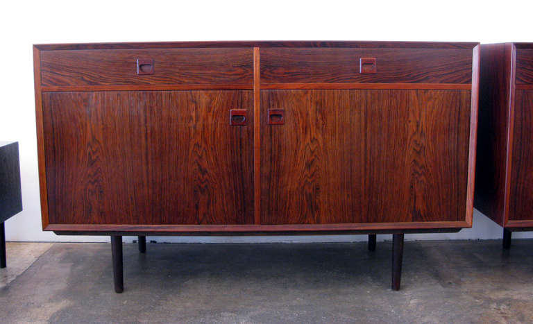 Pair of Brouer rosewood cabinets or sideboards with beautiful wood grain. Each cabinet has two drawers and three doors with a single shelf behind each. Dimensions shown are per cabinet.