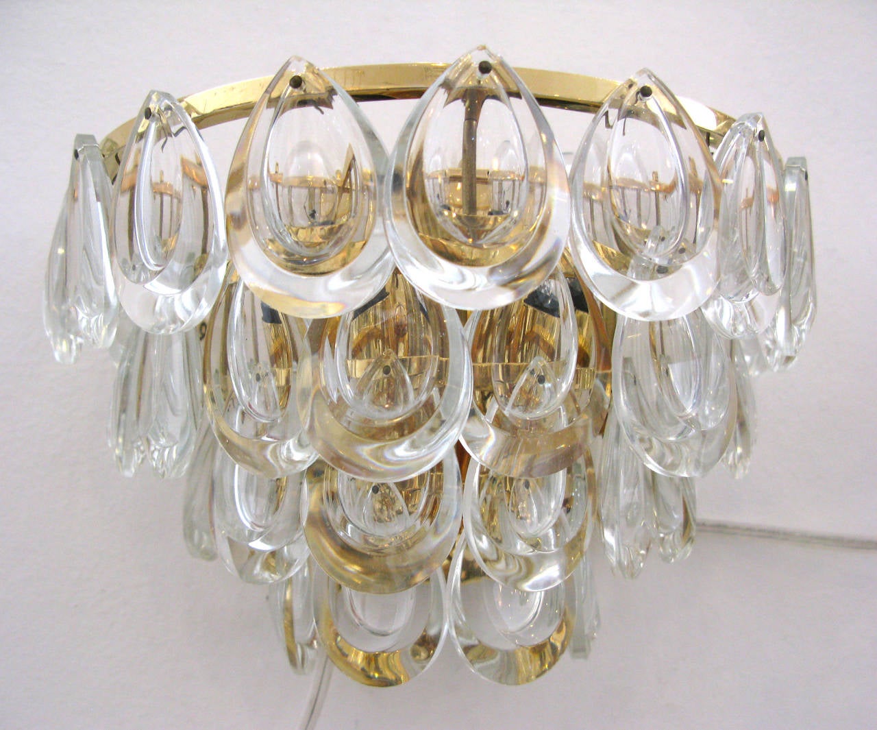 Beautiful pair of crystal and brass sconces designed by Gaetano Sciolari. Teardrop shaped optical crystal pieces hung on polished brass hardware.

 