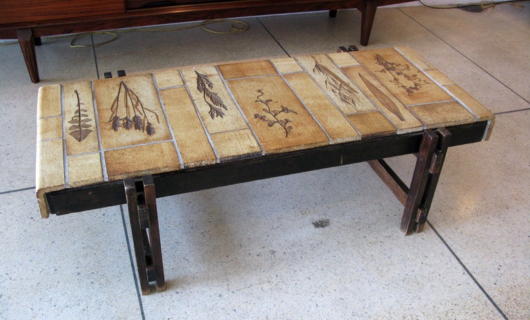 Original rectangular ceramic tile coffee table designed by Roger Capron.  Pressed leaves & plants in surface with jointed dark wooden legs.

* ON SALE - 60% OFF.  Originally $3400.  LIMITED TIME ONLY.  No further discounts apply.