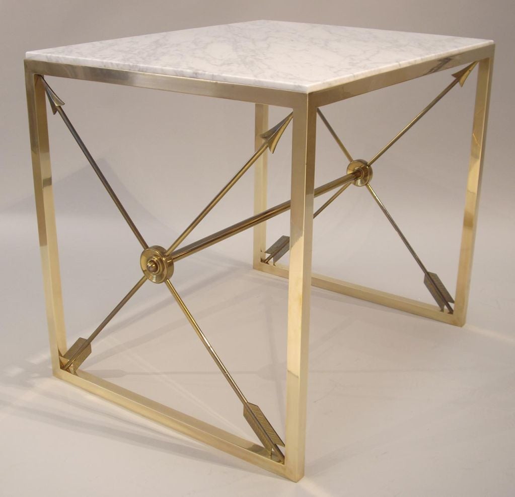 Exceptional pair of brass and marble tables. Neo classic style with arrow motif. The brass frames are hand polished but not lacquered.