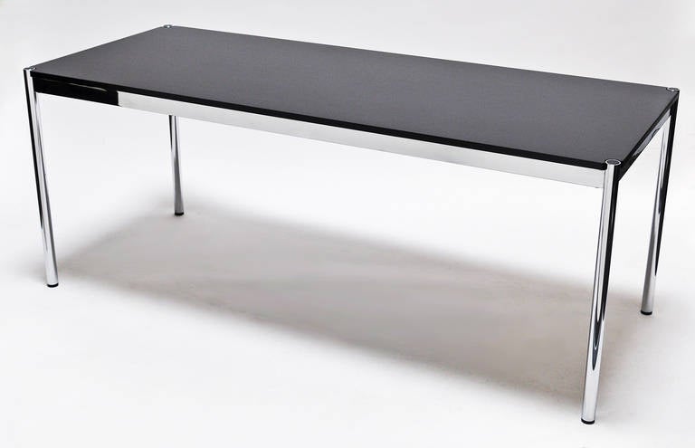 Minimalist design: polished steel and lacquered wood table by Haller.
This is a classic design that is both timeless and elegant.