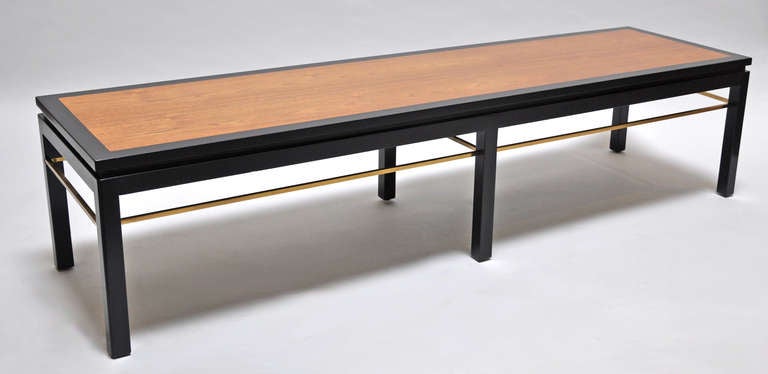 Pair of coffee table designed by Edward Wormley for Dunbar Furniture. Finished walnut with polished brass stretchers. Both tables are identical and are in beautiful condition.