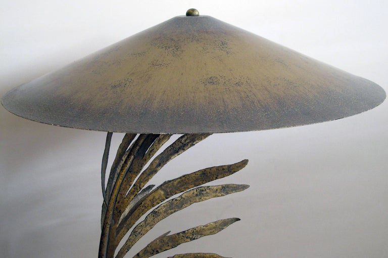 A striking and unusual pair of American 1960's gilt-metal palm frond lamps with original metal shades; each dramatically arching palm frond resting on a circular travertine base