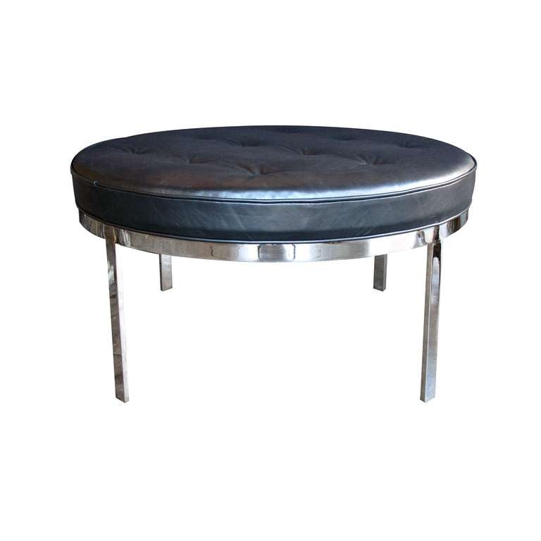 A generous and stylish circular chrome and leather bench by Milo Baughman; the round leather tufted seat above a chrome frame raised on 4 rectilinear supports; with slate blue leather upholstery