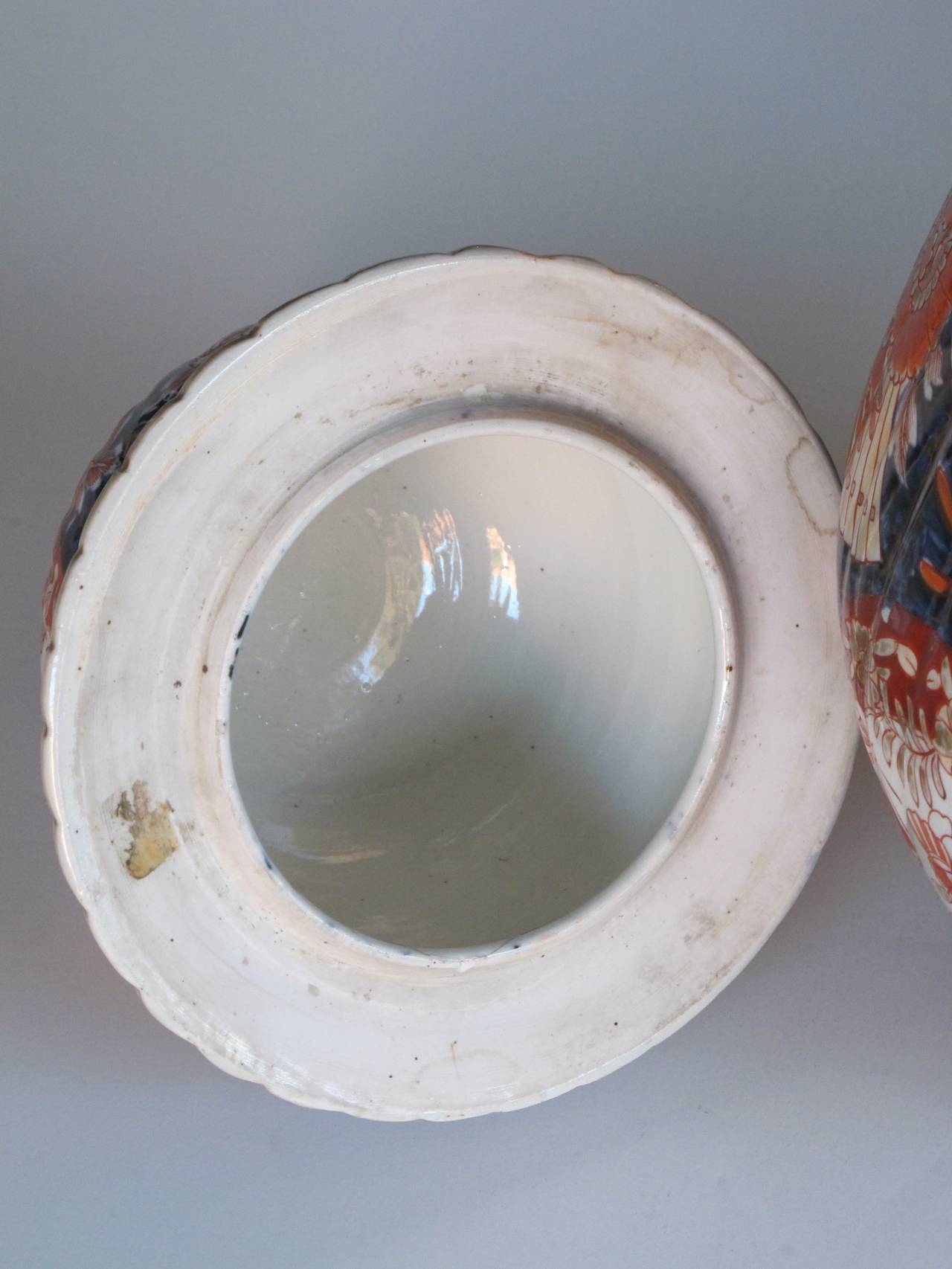 A large Japanese Imari porcelain covered ginger jar; the blue decoration fired onto the glaze and orange and gold applied by hand