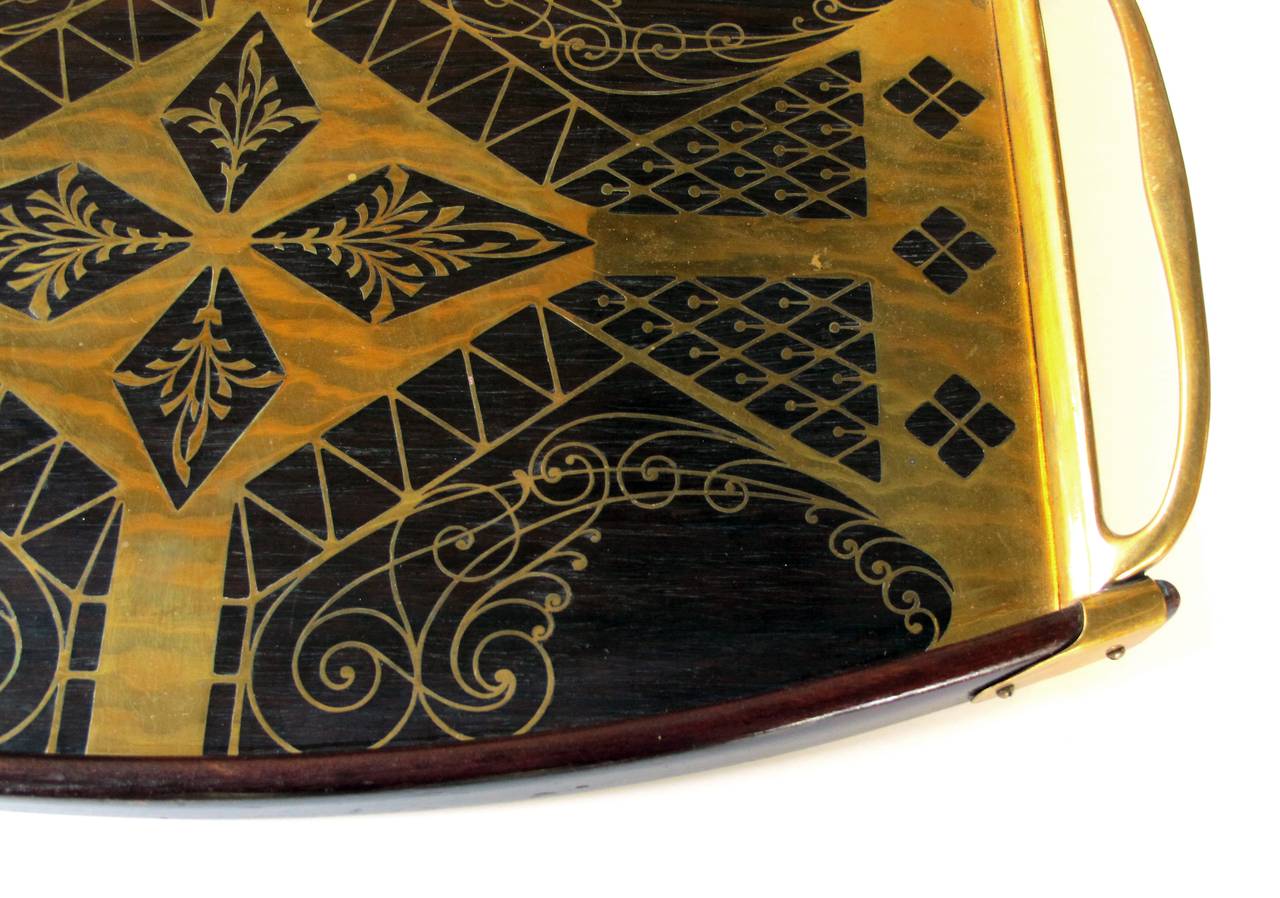 A good quality German Erhard and Sohne mahogany tray with brass inlay; the well-crafted tray with intricate brass inlay using the intarsia technique; flanked by openwork handles