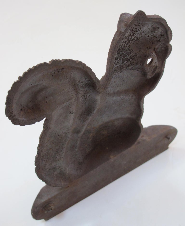 A charming American Bradley & Hubbard cast iron squirrel doorstop (Bradley & Hubbard Metalworks, 1852-1940); the upright squirrel standing on a log and gnawing on an acorn