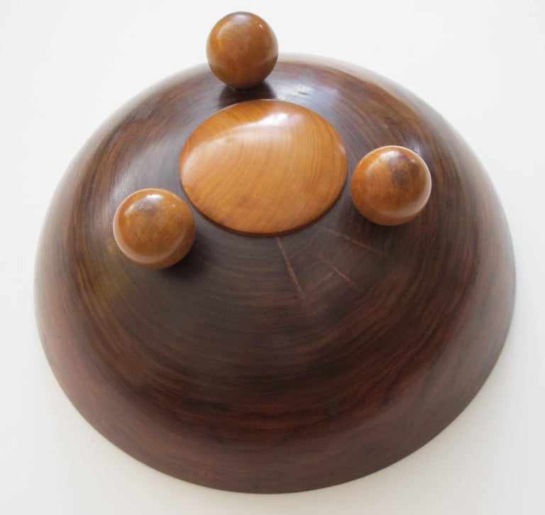 A richly-patinated English rosewood treenware bowl with inlaid star motif; the well-figured rosewood bowl centering a five-point inlaid star; raised on three spheroid feet.
