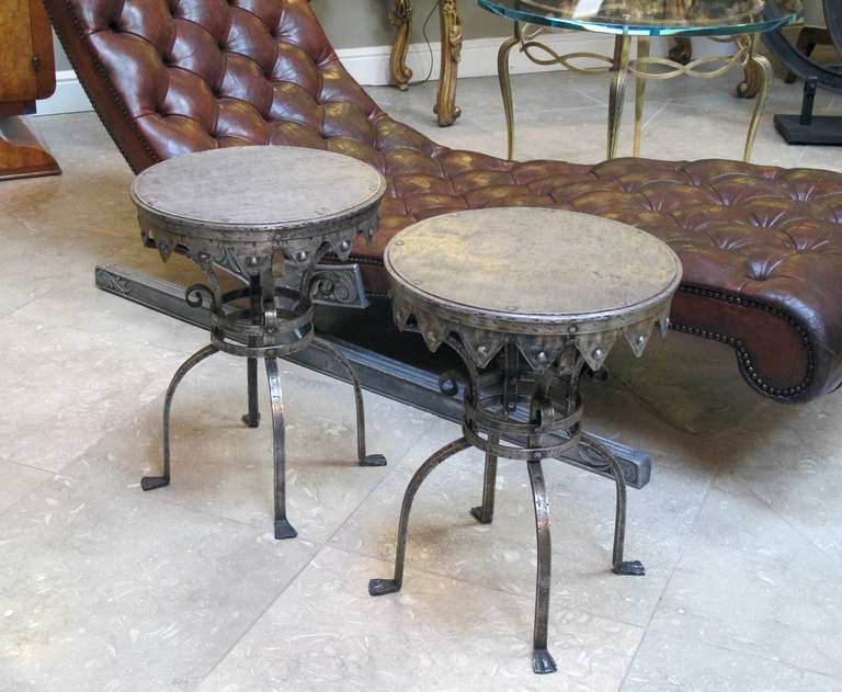 A good quality pair of continental wrought iron circular side tables; in the style of Samuel Yellin; each hand-wrought table with pointed apron above an openwork support raised on 4 bowed supports