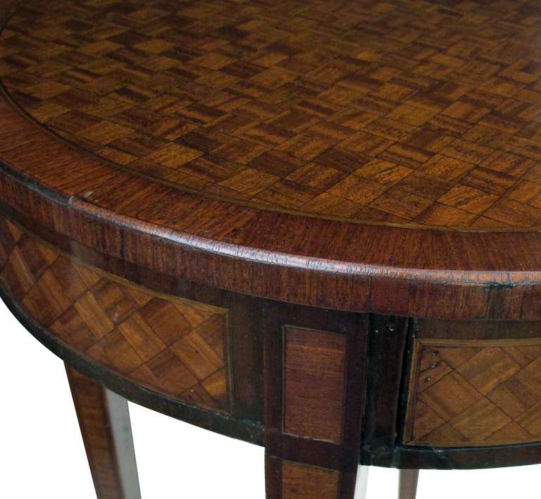 A tailored French Louis XVI style tulip and kingwood-veneered circular single-drawer side table; the basket-weave veneered top above a similar apron with single drawer; raised on 4 tapering quadrangular supports ending in brass capped feet