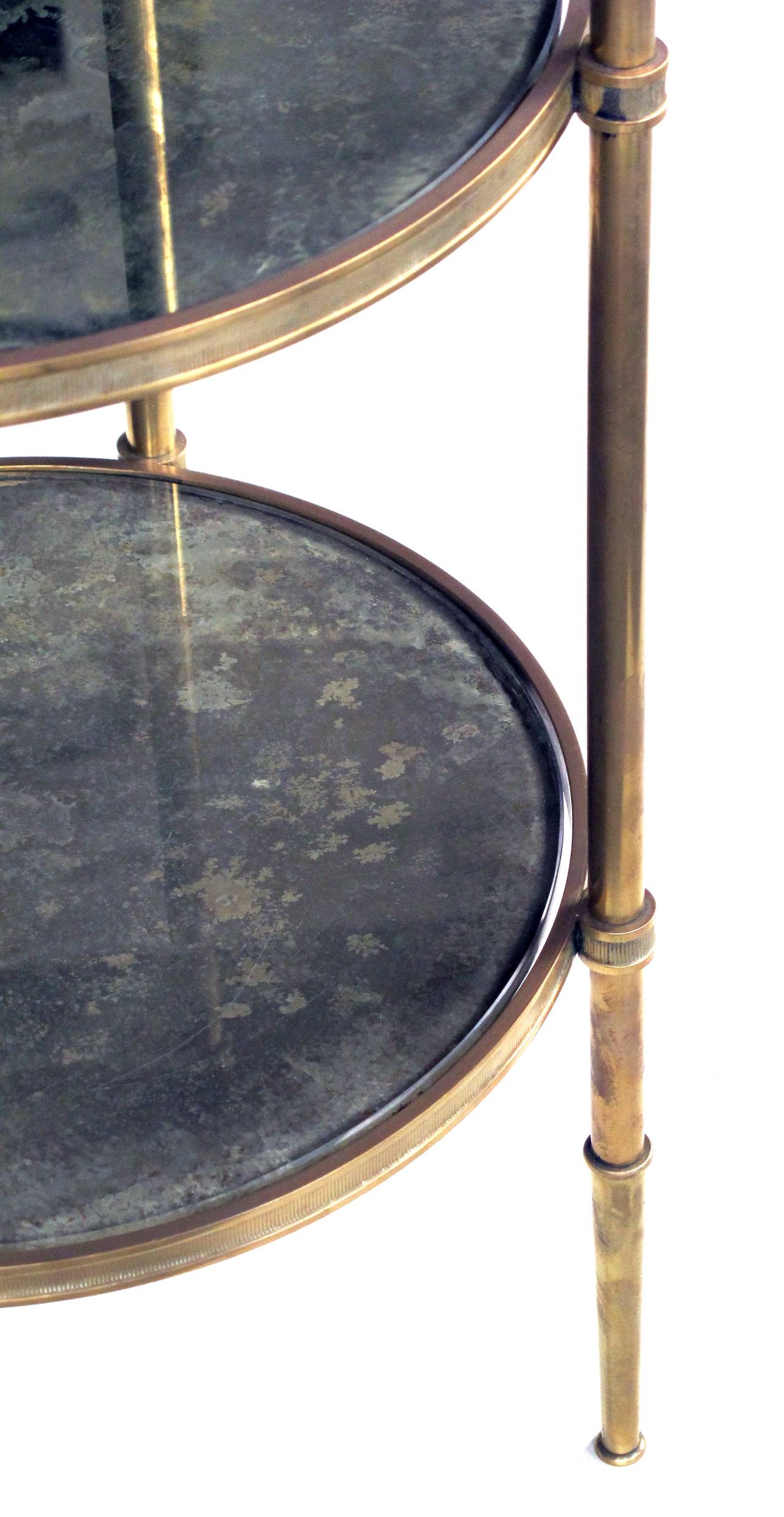 A good quality brass French 1950's 3-tier circular side table with mirrored shelves by Maison Bagues, Paris; the three tiered brass frame supporting antiqued mirrors