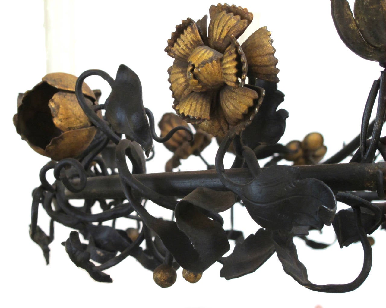 A fanciful Belgian six-light iron chandelier with scrolling floral and foliate vine. The openwork iron ring supporting six candle arms, adorned overall with meandering foliate vine with bold flower heads of lilies, roses, chrysanthemums and tulips.