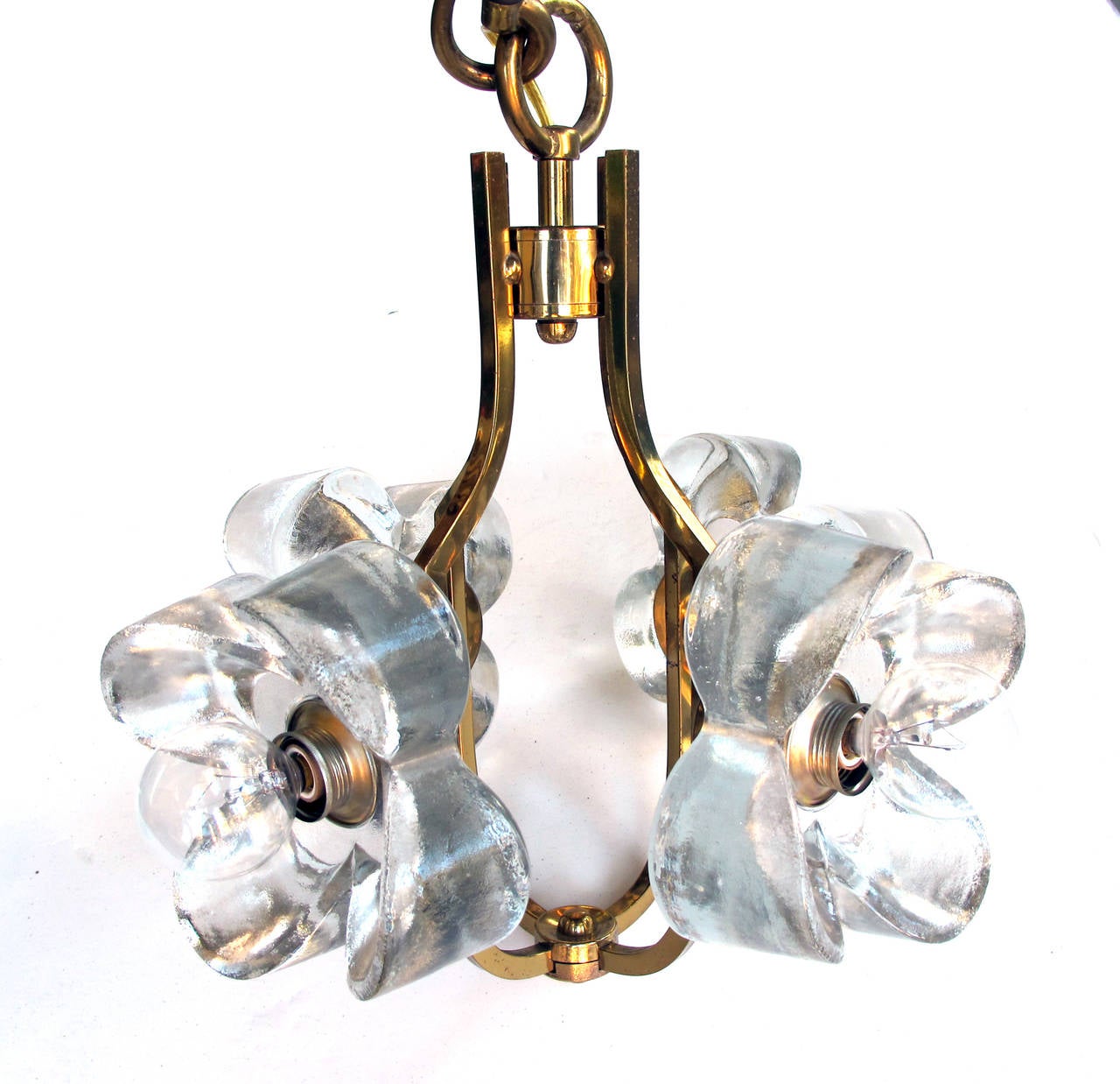 A whimsical Italian 1960s brass four-light chandelier or pendant with thickly molded glass flowers; all suspended by a separate brass rod; by AV Mazzega; the cage-form brass frame adorned with four robust glass flower heads.
