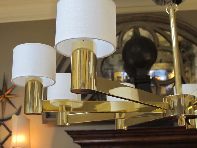 A stylish Italian 1960's brass 9-arm chandelier with linen shades; labeled 'Arredoluce Monza, Made in Italy'; the central hub emanating 9 rectilinear arms
