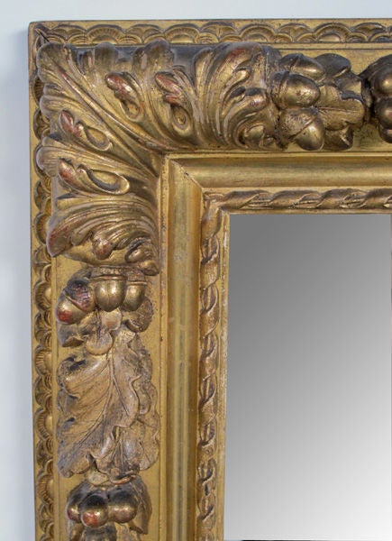 A deeply carved Italian neoclassical style rectangular giltwood mirror with laurel and oak leaf decoration; the originial rectangular plate within a giltwood frame adorned with boldly-carved laurel leaves and berries interspersed with oak leaves and