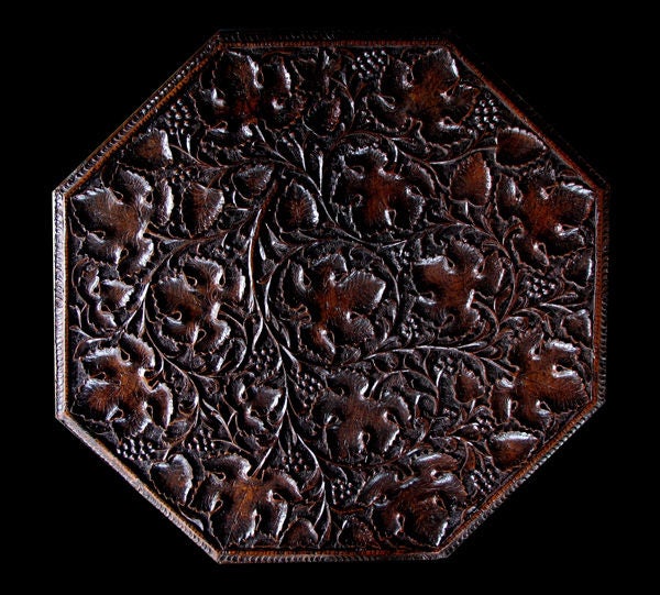 A large-scaled and well-carved Anglo Indian rosewood octagonal traveling table with carved grapevine decoration; the attached octagonal top on a conforming base decorated overall with a finely carved meandering grapevine motif