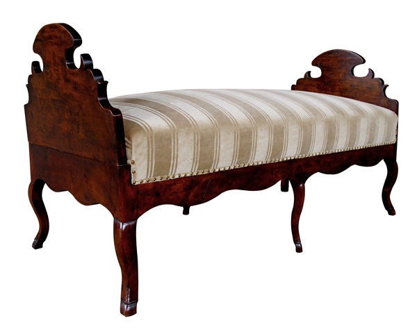 A charming and deeply patinated French provincial walnut day bed; the shaped removable ends flanking a long tight seat above a scalloped apron all raised on 6 curvaceous cabriole legs ending in hoof feet