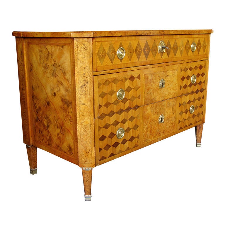 A handsome Swedish Gustavian alder root parquetry 3-drawer chest; the well-figured top with canted corners above a body fitted with 3 graduated drawers with parquetry veneer; raised on tapering quadrangular supports with gilt-bronze mounts
