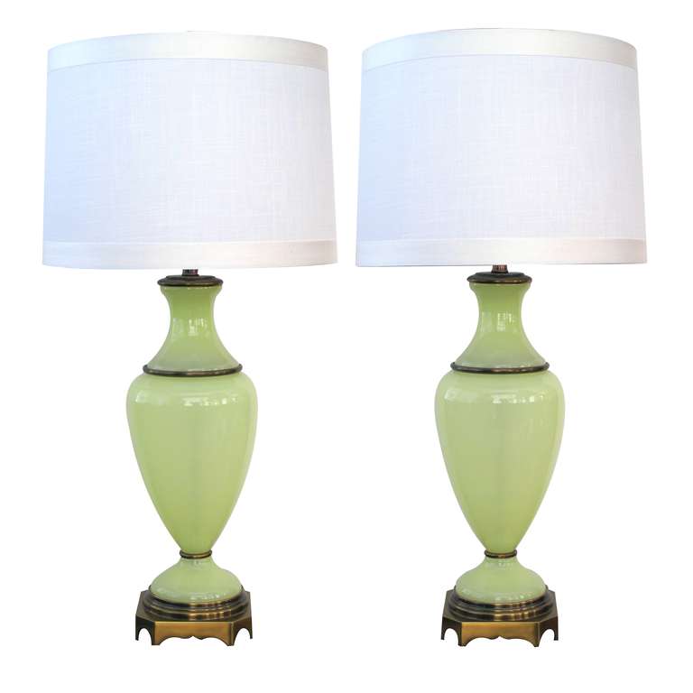An elegant pair of French mid-century chartreuse opaline glass lamps with brass fittings; made for Paul Hanson, New York; each of ampula form of a translucent acid green glass with brass fittings