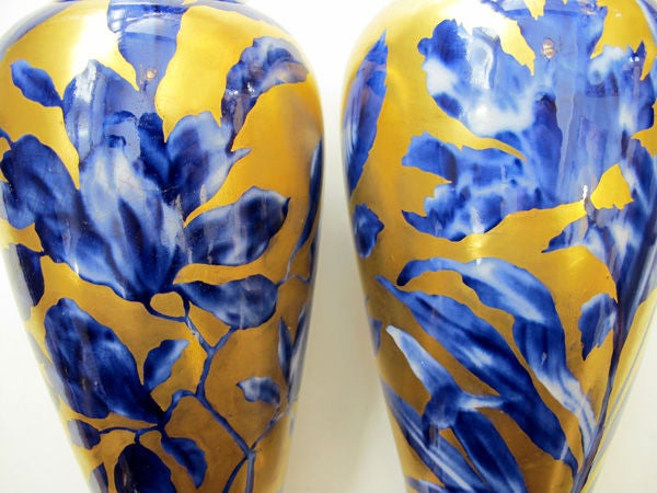 A fine pair of English Thomas Forester cobalt blue and gilt vases with iris decoration; stamped 'T.F. & Sons Ltd, England'; each with short everted lip above a tapering body ending in a splayed foot; painted with cobalt blue iris stems on a gilt