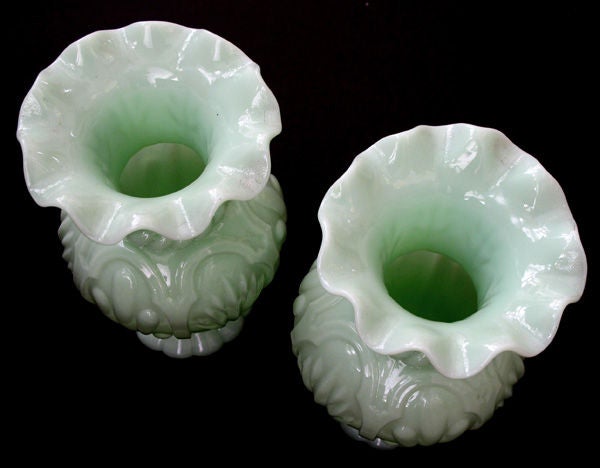 A delightful pair of French pale-green opaline baluster-form vases; each with everted scalloped lip above a bulbous body adorned with raised stylized foliage between ropetwist bands.