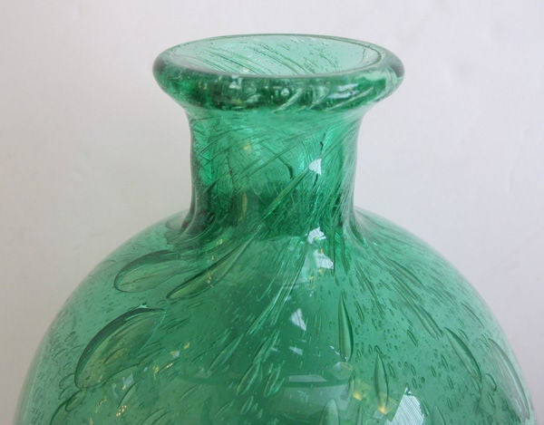 A thickly-modeled and boldly-scaled French Art Deco emerald green art glass bottle-form bubble vase; attributed to Charles Schneider; the short flared neck above a robust ovoid body all in a rich green art glass infused with 'water' bubbles.