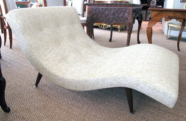 A curvaceous and stylish American mid-century s-shaped chaise lounge; designed by Adrian Pearsall for Craft Associates; the wide s-curved upholstered tufted seat raised on 4 turned supports with brass feet