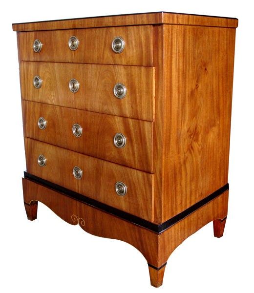An elegant Danish empire mahogany 4-drawer commode with ebonized highlights; the rectangular top above a conforming body fitted with 4 drawers over a gracefully scalloped apron raised on quadrangular supports