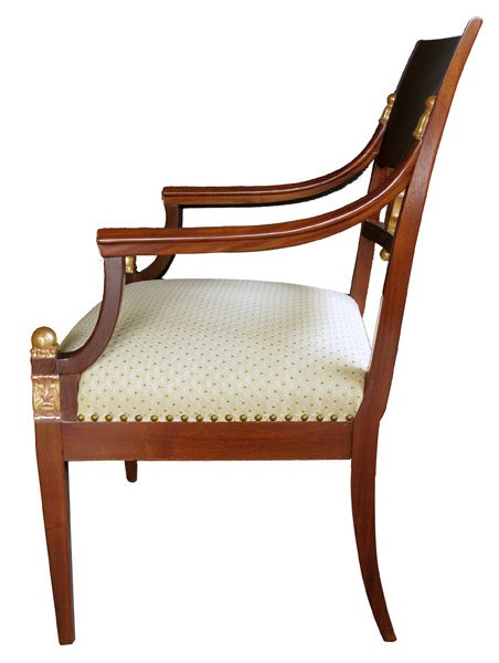 these very elegant chairs each with incurved backrest centering an inlaid wreath joining curved arms flanking by a tight seat; all raised on graceful tapering supports