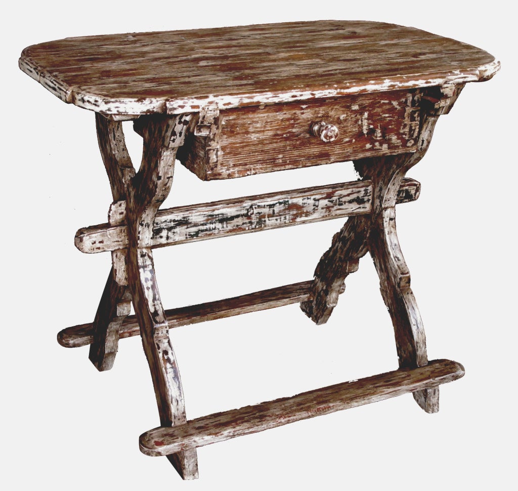 A rustic Danish baroque distressed pine single-drawer work table; the shaped rectangular top above a frieze drawer apron all raised on shapely x-form supports joined by cross stretchers