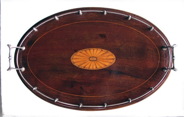 A good quality American mahogany oval tray on stand with inlaid shell and sterling silver gallery and handles; impressed silver hallmarks 'GJ' (Goodnow Jenks, Boston, MA 1893-1905); the oval tray centering an inlaid shell surrounded by a sterling