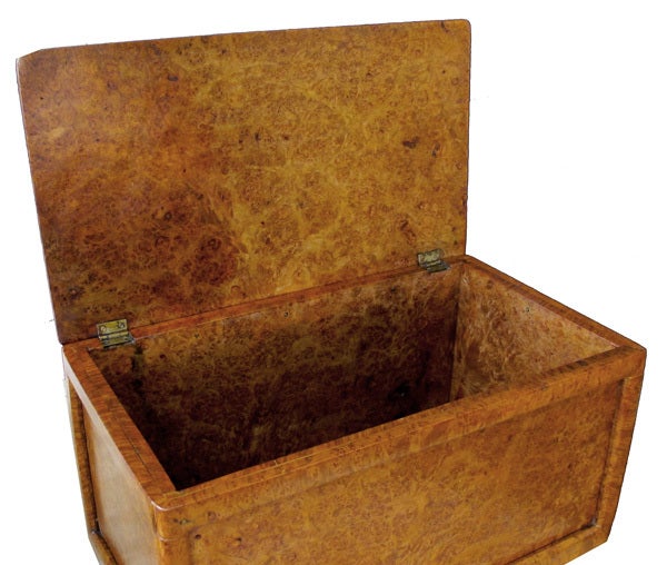 A large-scaled and well-figured English rectangular solid amboyna box; the whole of richly-figured and patinated amboyna with hinged rectangular top above a conforming body all raised on later spheroid feet