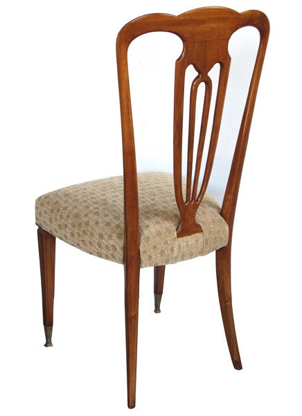 A stylish set of eight Italian 1940's pear wood shield-back dining chairs; each with arching crest above an openwork shield-form splat; above a serpentine tight seat all raised on tapering quadrangular supports with brass collar and foot; with