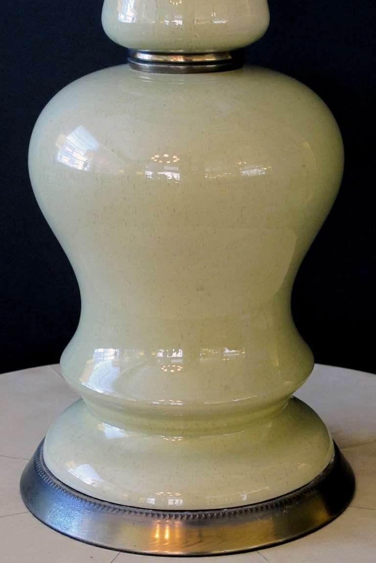 A shapely pair of American mid-century celadon green baluster-form ceramic lamps; by Frederick Cooper, Chicago; each with long neck above a bulbous body flaring at the base; rewired; excellent condition with no chips or cracks; lamp shades as is.