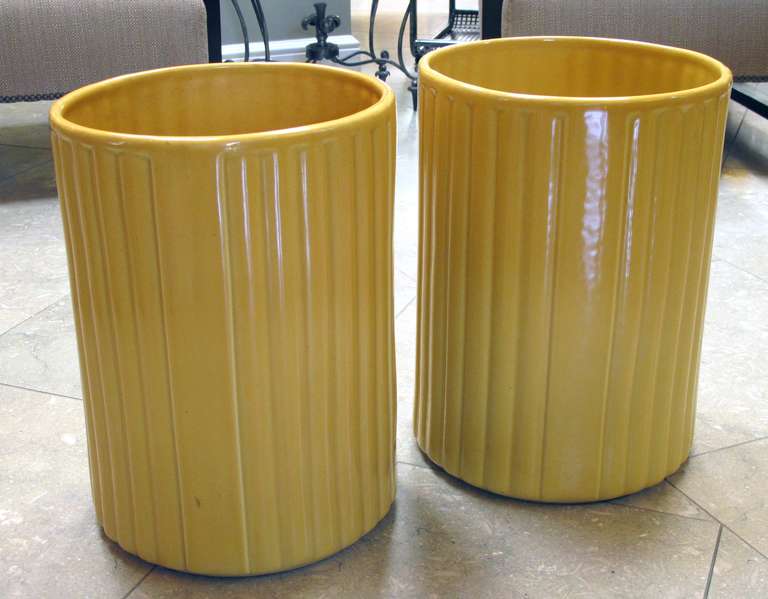 A large-scaled pair of American 1940s golden-yellow glazed ceramic umbrella jars; designer Harold Holman, Alamo Pottery, San Antonio, Texas; each large ribbed jar of cylindrical form decorated in a soft yellow glaze over white clay; with impressed
