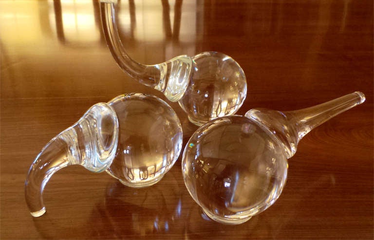 A set of three shimmering and well-modeled American 1980's Steuben Crystal elephant figures; New York 1980 Paul Schultz; each portly crystal figurine in one of three poses: trunk down, trunk up and trunk out; signed 'Steuben PS'