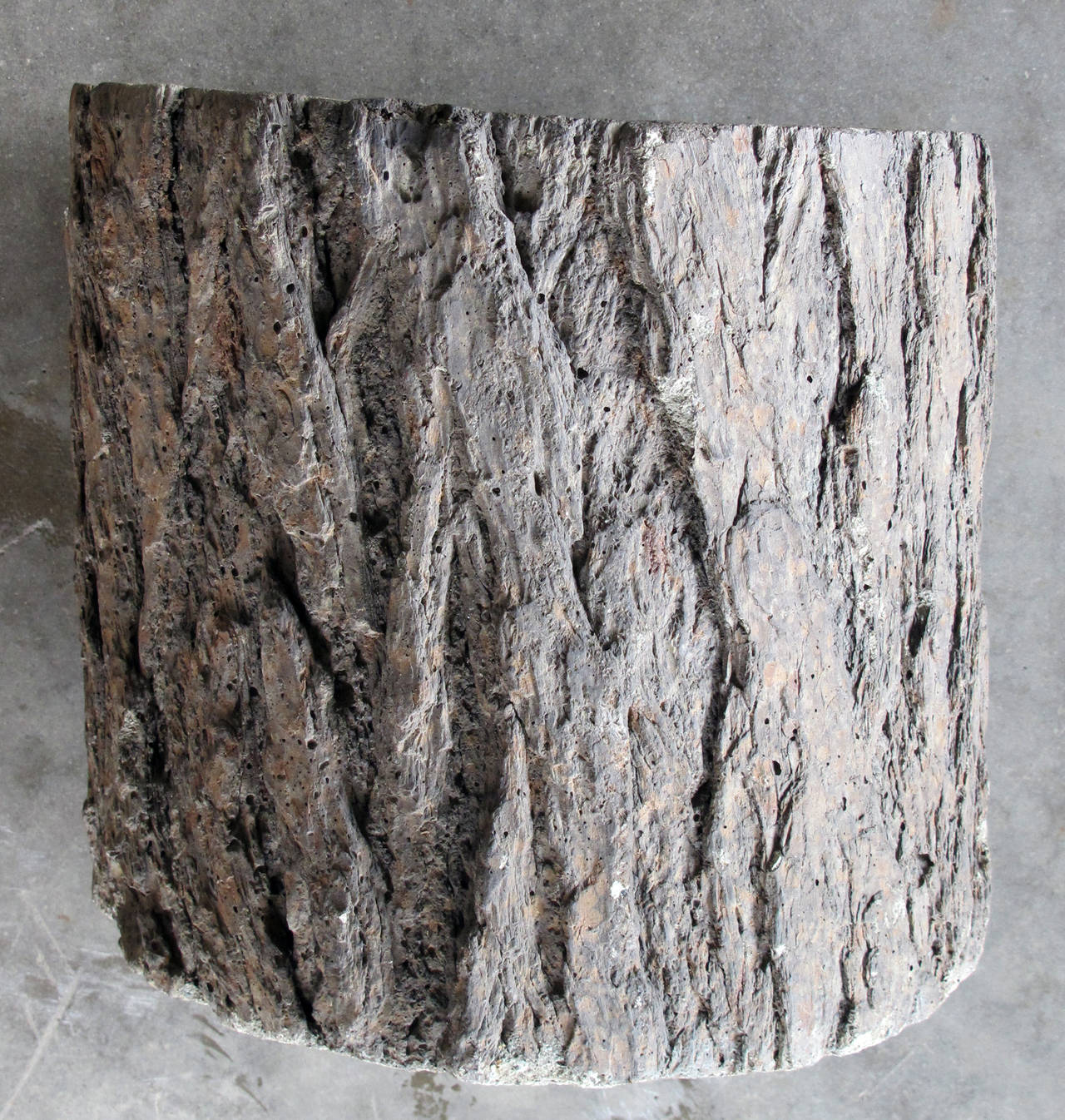 A good quality and well-rendered pair of French faux bois concrete planters; each of asymmetrical cylindrical form with realistic bark surface; maker's mark to underside