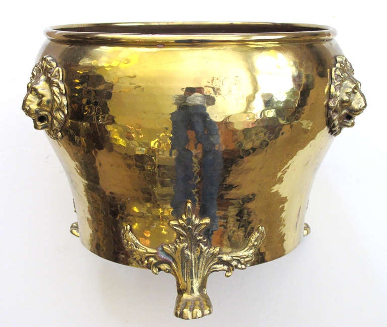 A rare and large-scaled Imperial Russian hand-hammered brass jardiniere with lion head mounts; Imperial Russia Stamp, City of Tula (in Cyrillic); the circular vessel with rolled lip above a portly body tapering to the foot; raised on 3 exhuberant