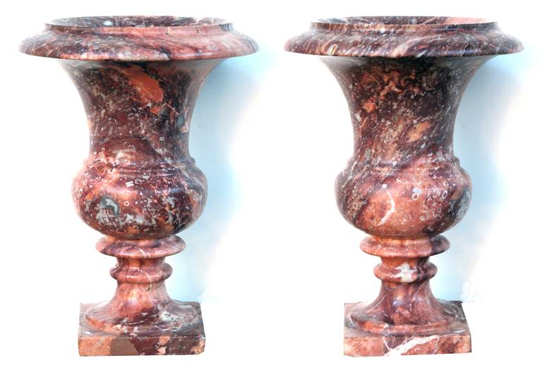 An elegant pair of French campagna urns of opera-fantastico marble; each well-figured urn of campagna form with everted lip above a tapering neck and compressed mid-section all resting on a square plinth