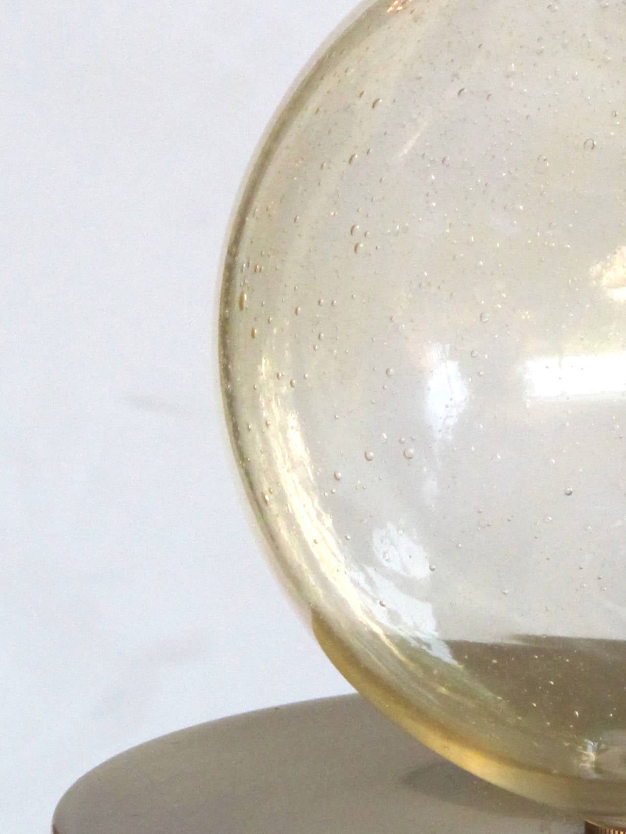 A striking Murano mid-century lamp of stacked gold orbs; consisting of 2 large glass orbs resting on an over-scaled brushed brass cylindrical base