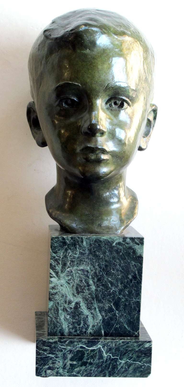 A beautifully rendered American 1940's bronze bust of a young boy on marble plinth; signed 'JG Kendall 1945' (Gorham Co. Foundry); the richly-patinated bust of a young boy with serene direct gaze and short cropped hair; raised on a green marble